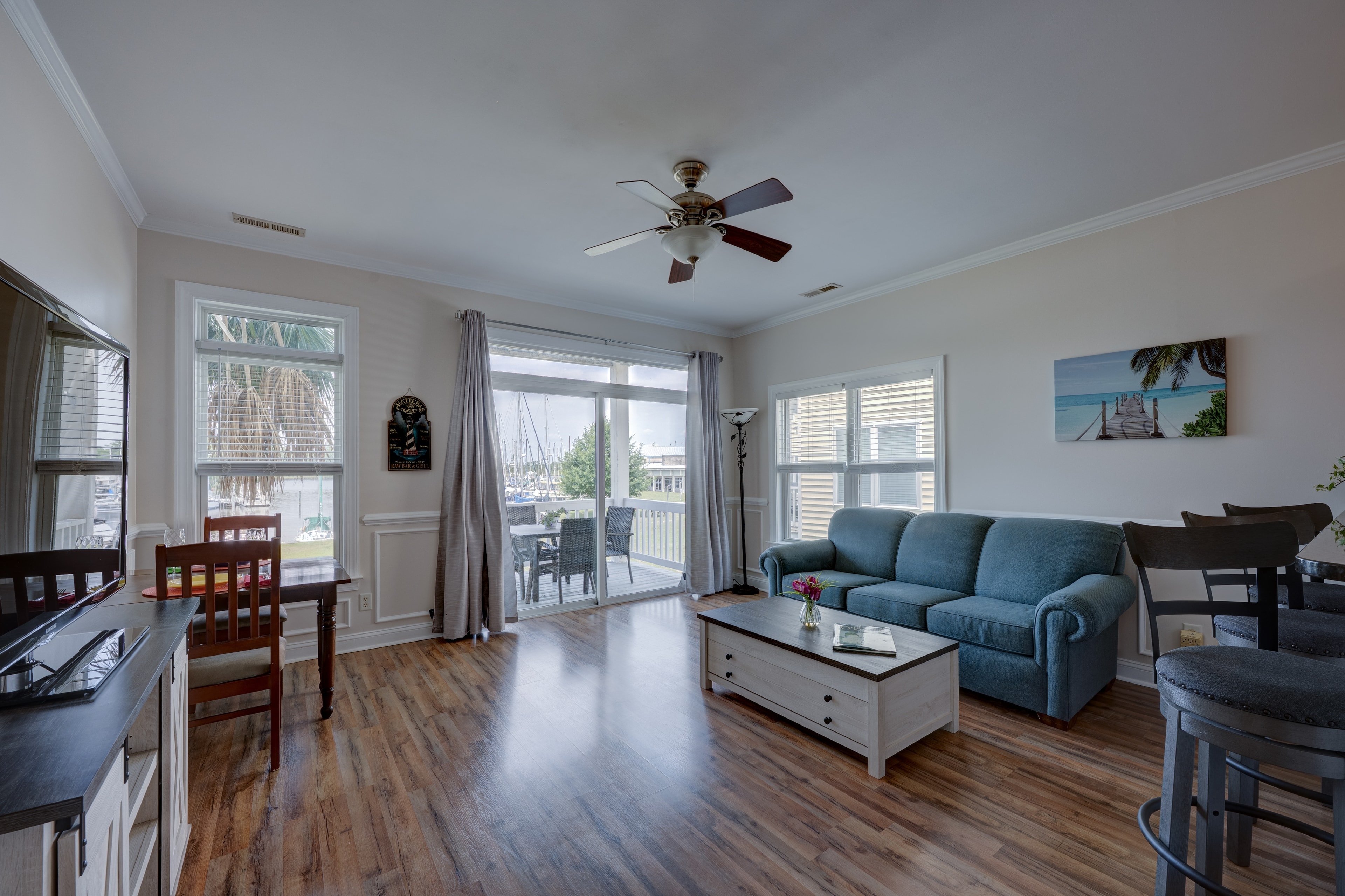 Living room with blue sofa, hardwood floors and marina view