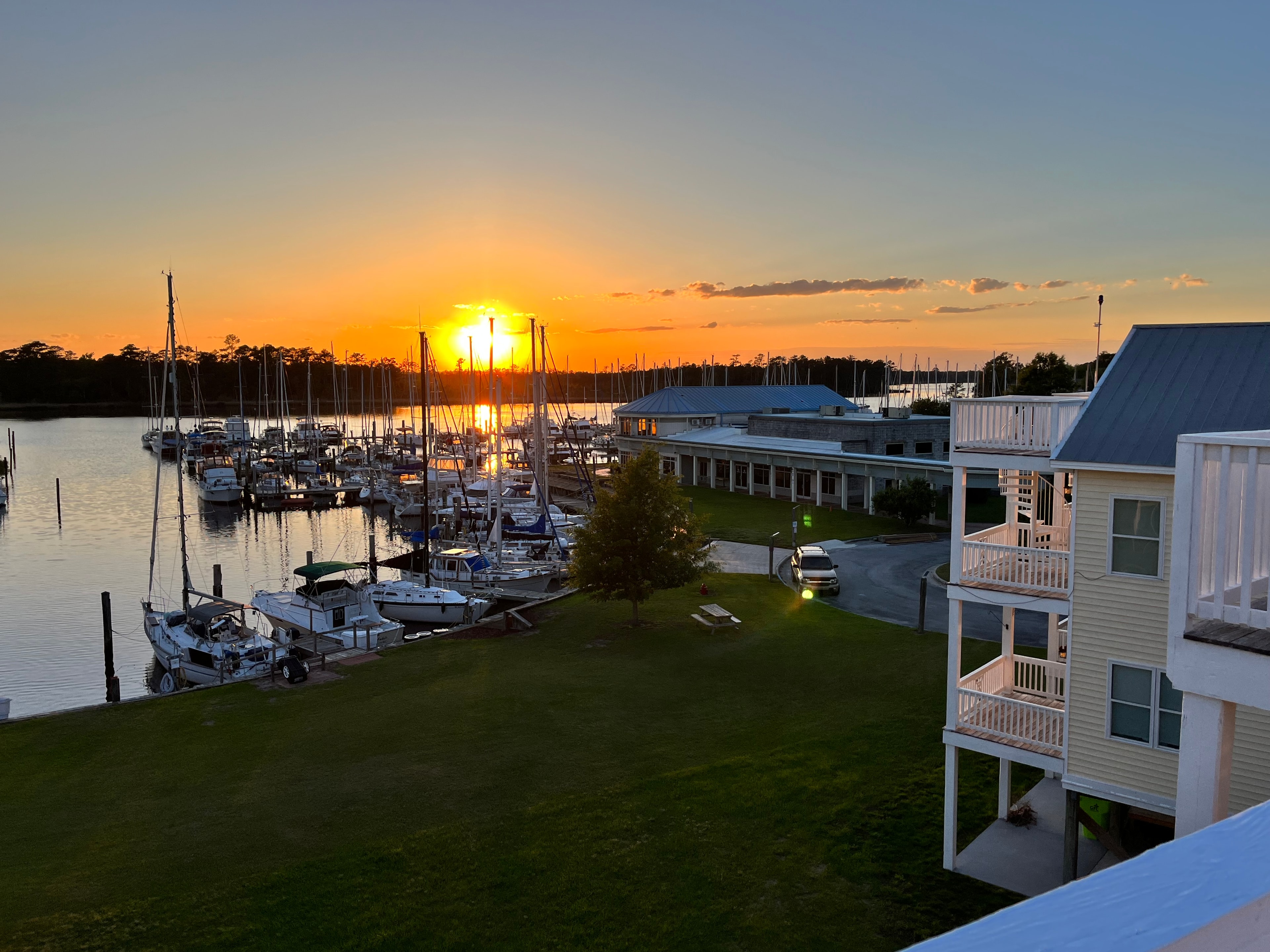 Marina at sunset viewed from the deck, showing the marina building and townhouse in the foreground
